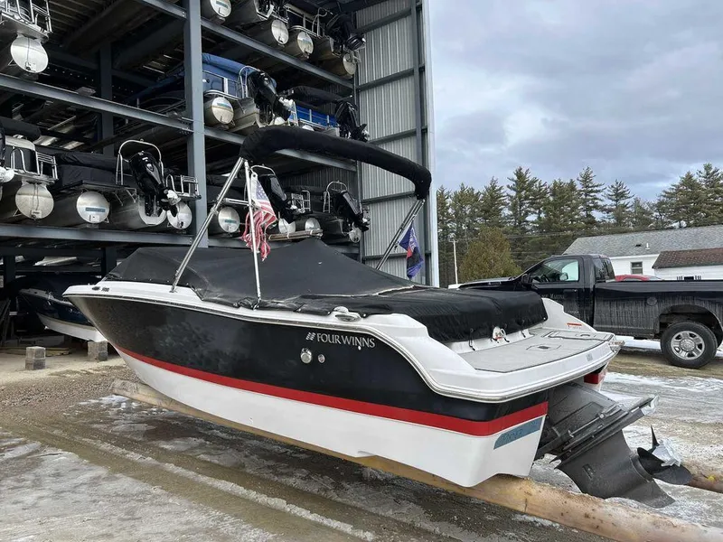 Slide: The Image of 2018 Four Winns Horizon 190 boat in storage, black and white with red stripe. - 3