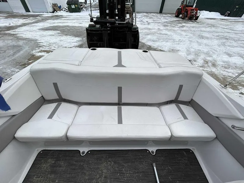 Slide: The Image of 2018 Four Winns Horizon 190 boat interior with white cushioned seating, parked on snowy ground. - 7