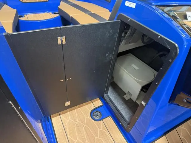 Slide: The Image of 2025 Yamaha Boats 222XD interior storage compartment with open door, showcasing sleek design and functionality. - 16