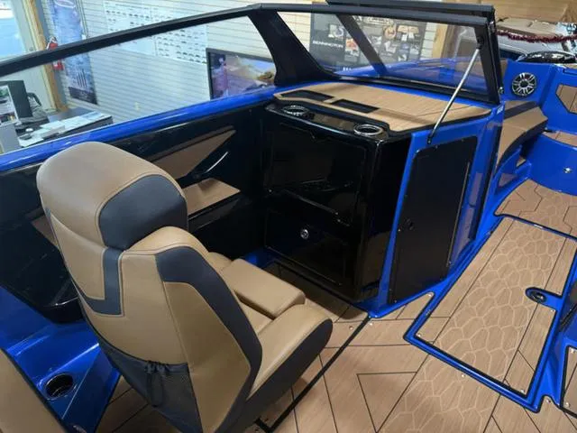 Slide: The Image of 2025 Yamaha Boats 222XD interior with tan and black seating, blue accents, and modern dashboard. - 17