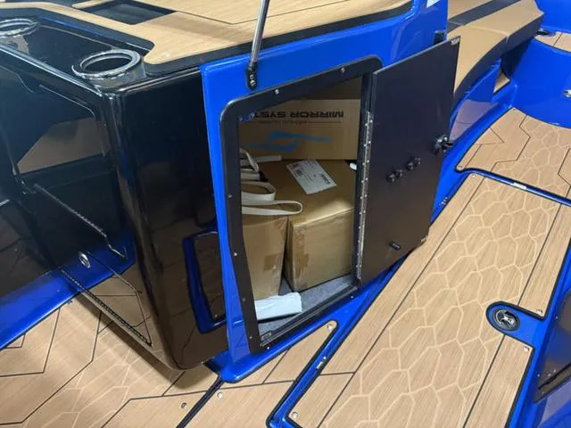 Slide: The Image of 2025 Yamaha Boats 222XD storage compartment with open door, revealing interior contents. - 18