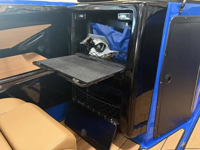 Slide: The Image of 2025 Yamaha Boats 222XD interior storage compartment with open shelf and gear. - 19