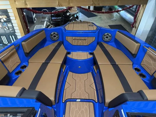 Slide: The Image of 2025 Yamaha Boats 222XD interior with blue and tan seating, speakers, and cup holders. - 22