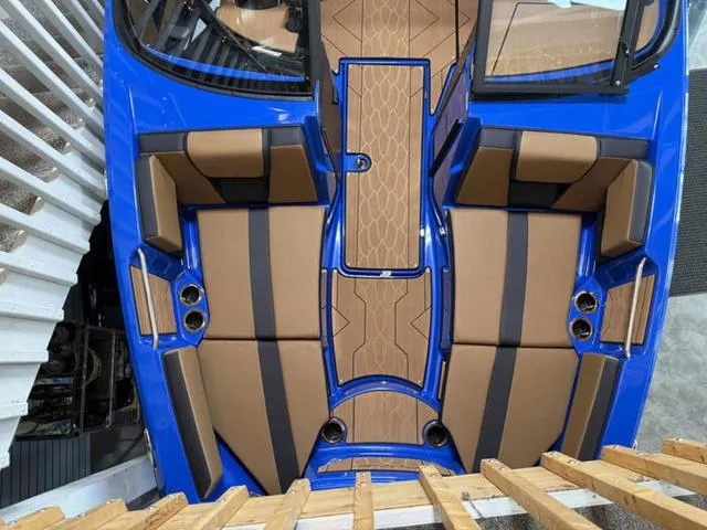 Slide: The Image of 2025 Yamaha Boats 222XD interior, featuring blue and brown seating with modern design. - 23