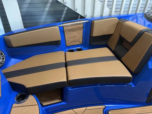 Slide: The Image of 2025 Yamaha Boats 222XD interior with tan and black seating, blue accents, and cup holders. - 24