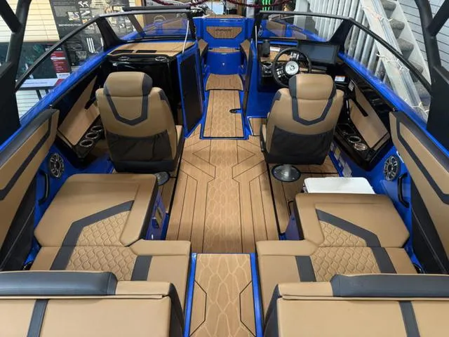 Slide: The Image of 2025 Yamaha Boats 222XD interior with tan and black seating, modern dashboard, and blue accents. - 4