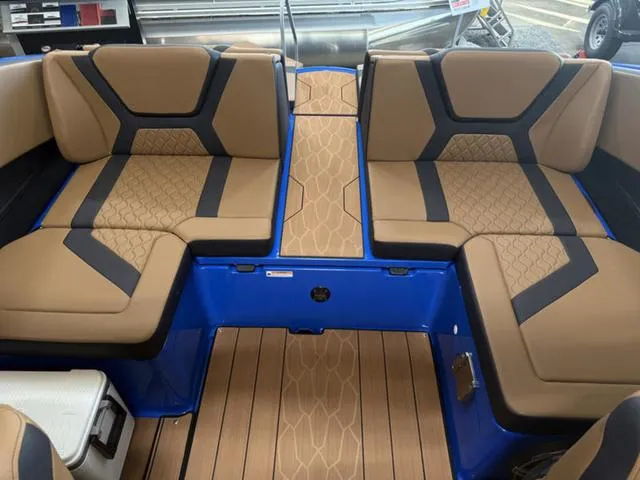 Slide: The Image of 2025 Yamaha Boats 222XD interior with tan and black seating, blue accents, and wood-patterned flooring. - 6