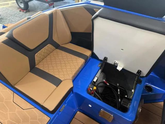 Slide: The Image of 2025 Yamaha Boats 222XD interior with tan and black seating, open storage compartment. - 9