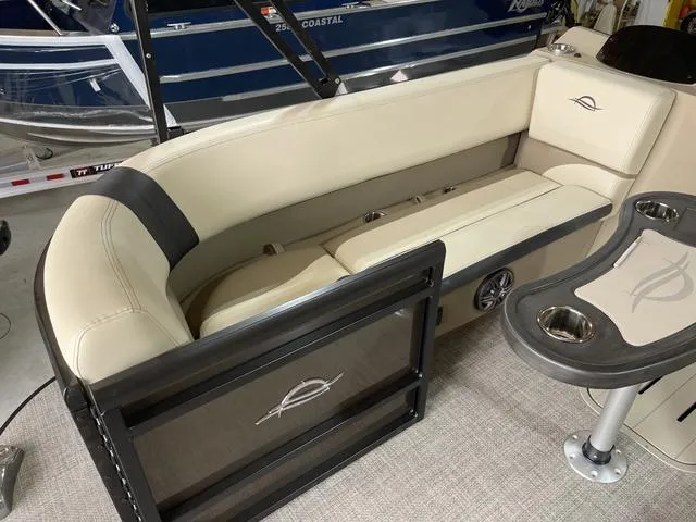 Slide: The Image of 2025 SunCatcher Select 322SS boat interior with beige seating and cup holders. - 10