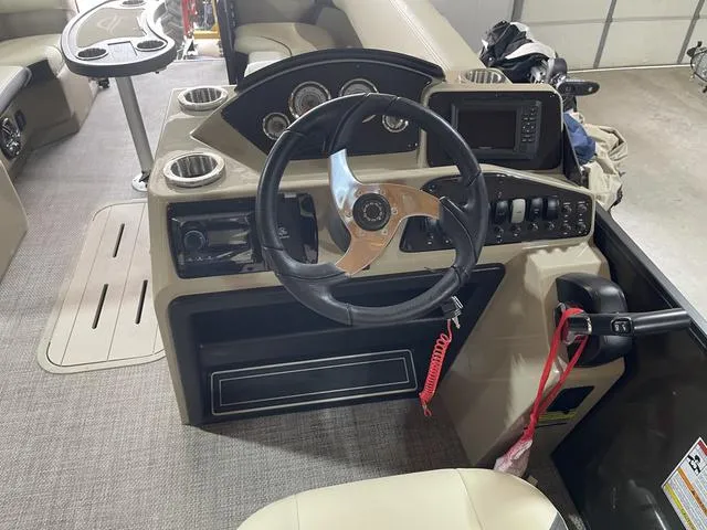 Slide: The Image of 2025 SunCatcher Select 322SS boat dashboard with steering wheel and control panel. - 13