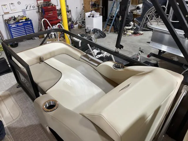Slide: The Image of 2025 SunCatcher Select 322SS boat interior with beige seating in a workshop setting. - 18