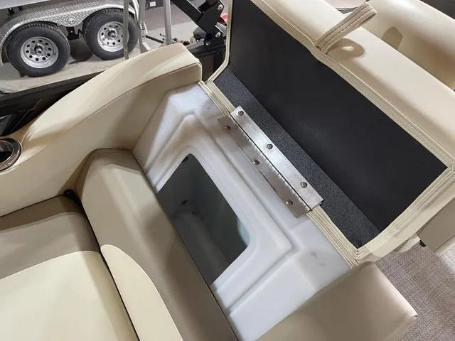 Slide: The Image of 2025 SunCatcher Select 322SS boat seat storage compartment, open with visible interior. - 19