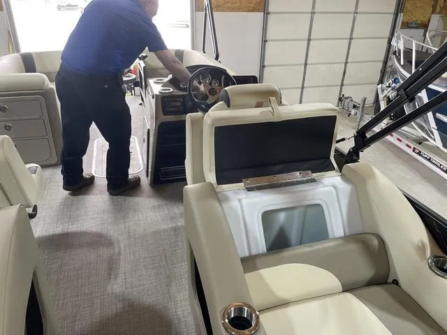 Slide: The Image of 2025 SunCatcher Select 322SS interior with steering console and seating in a garage. - 20