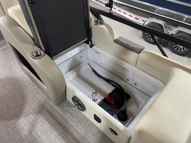 Slide: The Image of Open storage compartment in 2025 SunCatcher Select 322SS boat with cup holders and wiring. - 21