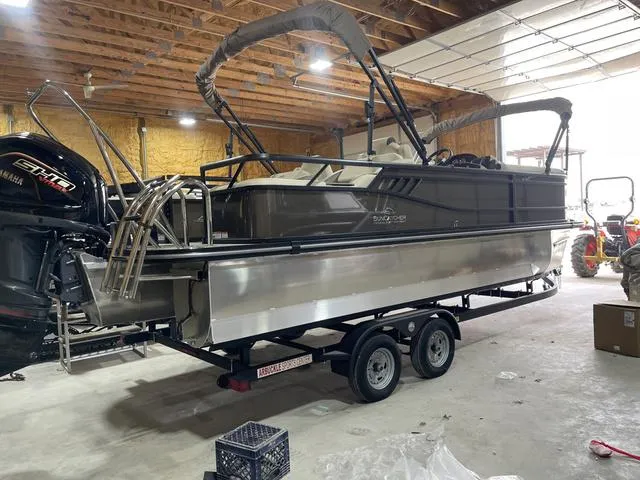 Slide: The Image of 2025 SunCatcher Select 322SS pontoon boat in a garage, on a trailer. - 3