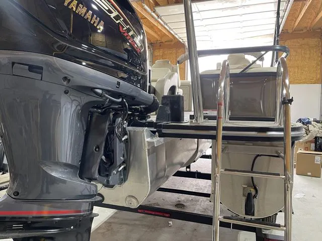 Slide: The Image of 2025 SunCatcher Select 322SS boat with Yamaha outboard motor in a garage. - 5
