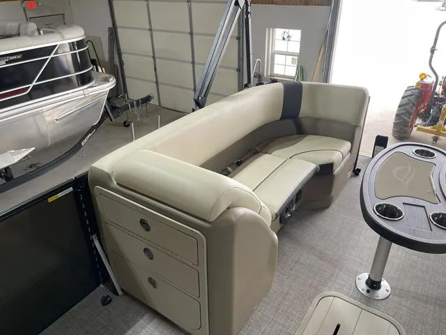 Slide: The Image of 2025 SunCatcher Select 322SS pontoon boat interior with beige seating and table. - 6