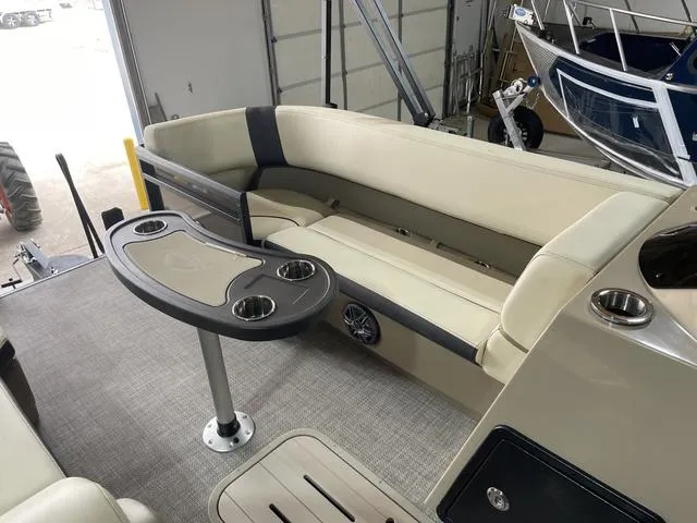 Slide: The Image of 2025 SunCatcher Select 322SS boat interior with beige seating and table. - 7