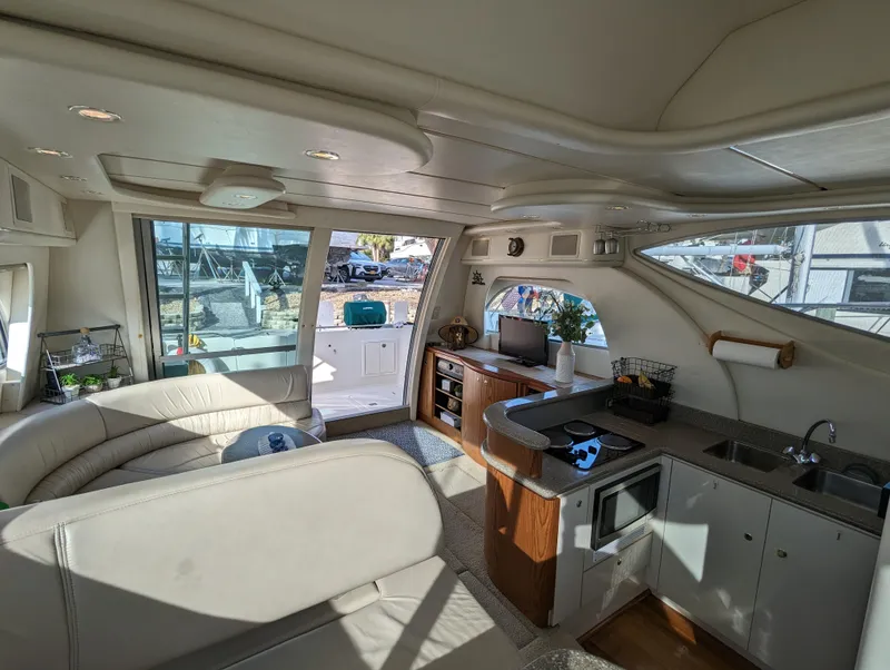 Slide: The Image of Interior of 1999 Maxum 4100 SCB yacht with modern kitchen and seating area. - 12