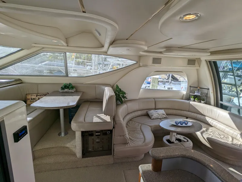 Slide: The Image of Interior of 1999 Maxum 4100 SCB yacht with beige seating and dining area. - 14