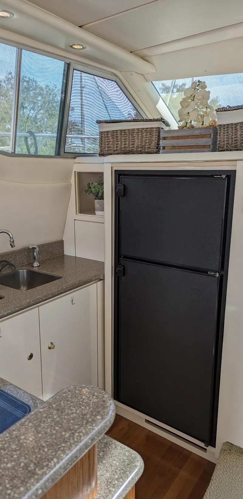 Slide: The Image of 1999 Maxum 4100 SCB yacht kitchen with black fridge, sink, and countertop. - 19