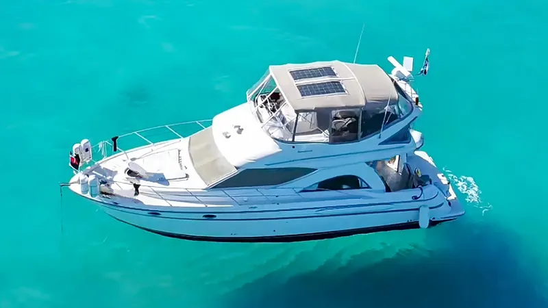 Slide: The Image of 1999 Maxum 4100 SCB yacht on clear turquoise water. - 2