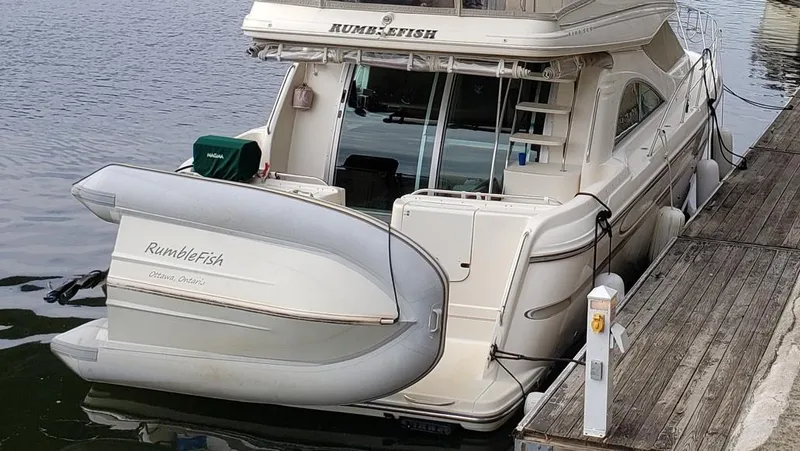 Slide: The Image of 1999 Maxum 4100 SCB yacht docked with inflatable boat attached. - 3