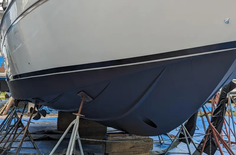 Slide: The Image of 1999 Maxum 4100 SCB yacht on dry dock, hull supported by stands. - 30