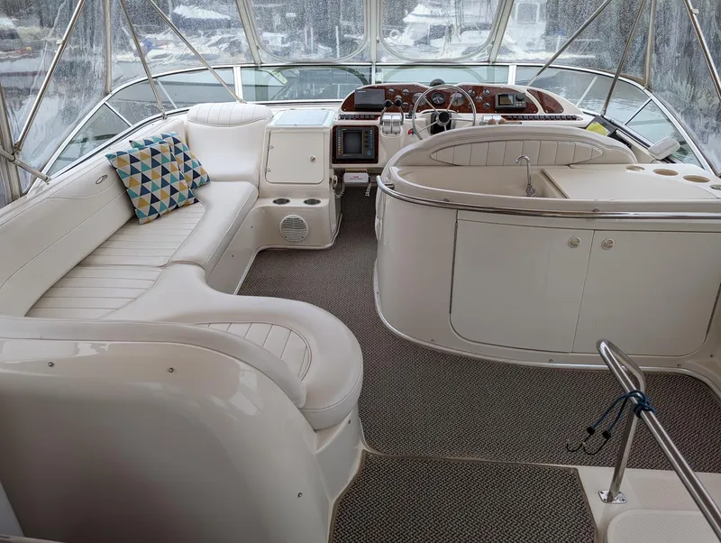 Slide: The Image of 1999 Maxum 4100 SCB yacht interior with plush seating and modern navigation equipment. - 5