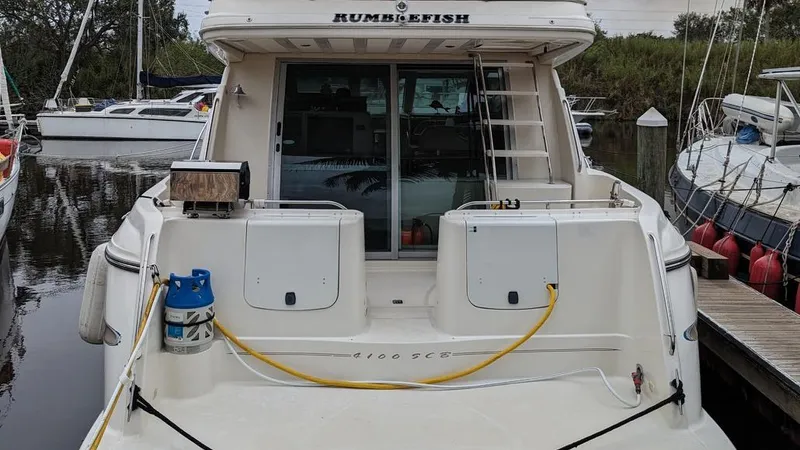 Slide: The Image of 1999 Maxum 4100 SCB yacht docked at marina, rear view with equipment visible. - 9