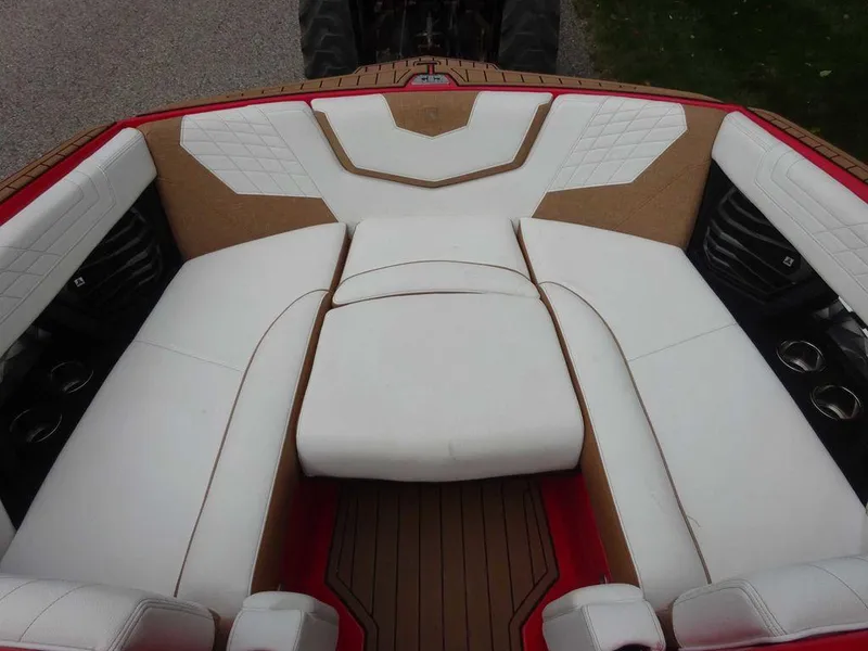 Slide: The Image of 2021 Nautique G23 boat interior with white and tan seating, featuring cup holders and stylish design. - 15
