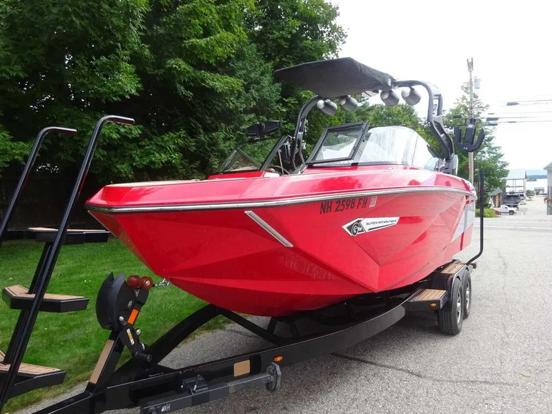 Slide: The Image of 2021 Nautique G23 boat in vibrant red on a trailer, parked outdoors. - 4