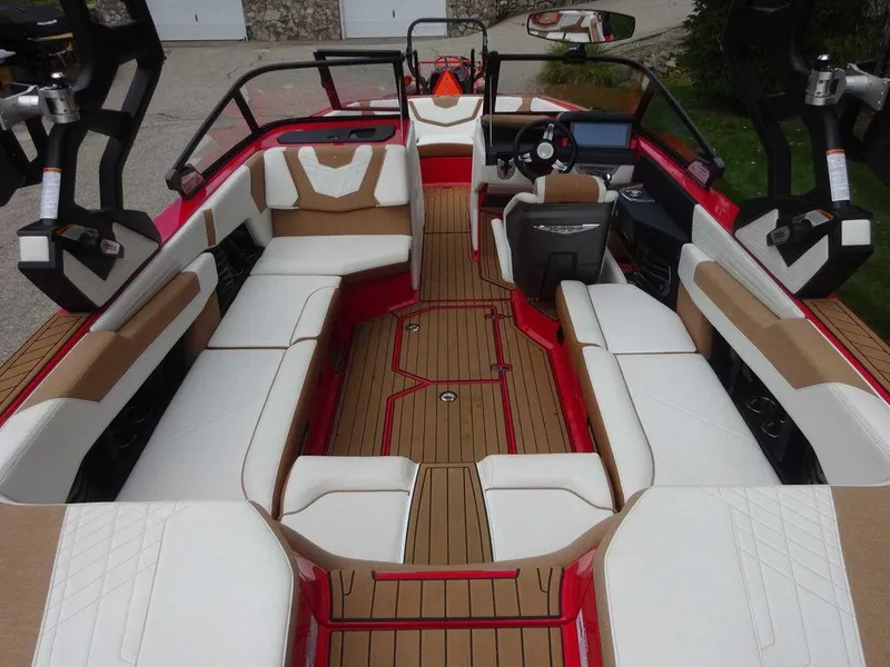 Slide: The Image of 2021 Nautique G23 boat interior with red and white seating, modern dashboard, and spacious layout. - 6