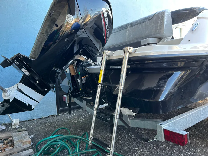 Slide: The Image of 2024 Bayliner Element M19 boat with Mercury outboard motor and ladder, on a trailer. - 9