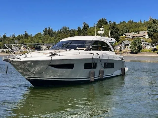 The Image of 2017 Jeanneau Leader 46 yacht on calm water near a wooded shoreline. - 0