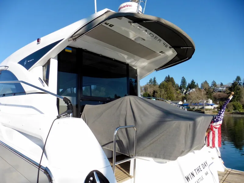 Slide: The Image of 2017 Jeanneau Leader 46 yacht docked, rear view with covered seating area and American flag. - 6