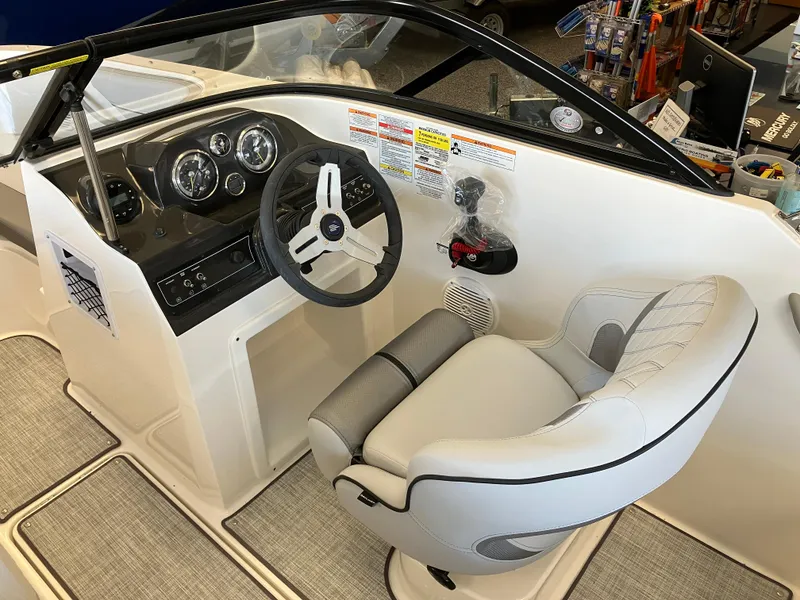 Slide: The Image of 2024 Bayliner VR4 Bowrider OB cockpit with steering wheel and captain's chair. - 4