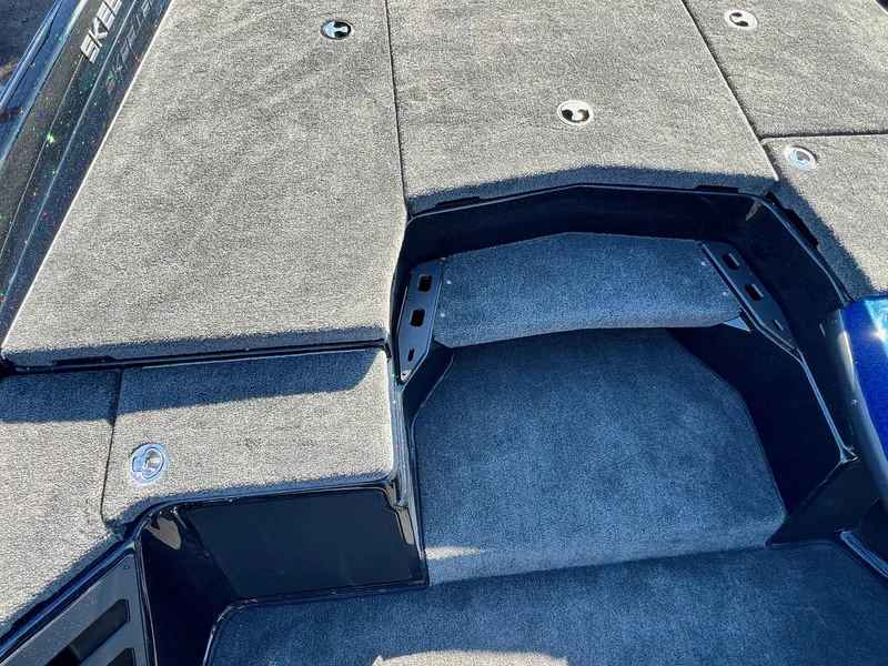 Slide: The Image of 2025 Skeeter ZXR 20 SE boat interior with carpeted deck and storage compartments. - 10