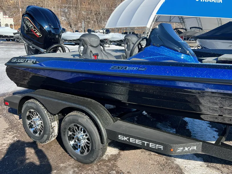 Slide: The Image of 2025 Skeeter ZXR 20 SE boat on trailer, featuring sleek design and shiny blue finish. - 13