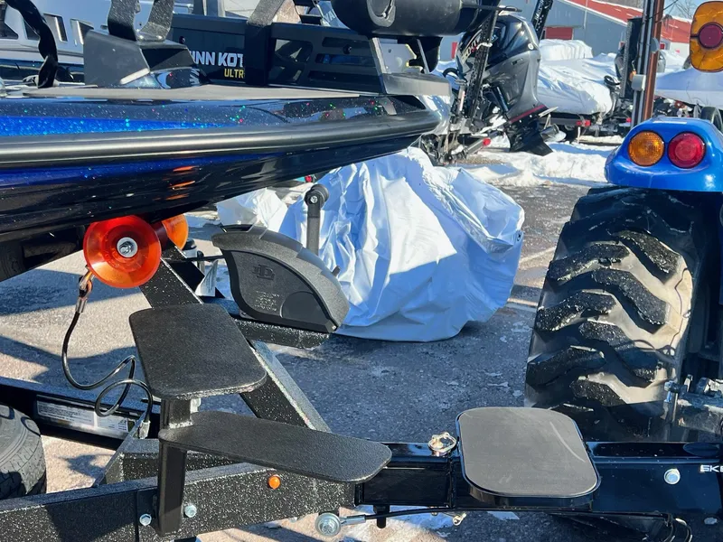 Slide: The Image of 2025 Skeeter ZXR 20 SE boat trailer with orange roller and black step pads. - 21