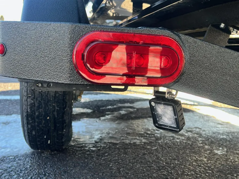 Slide: The Image of Close-up of 2025 Skeeter ZXR 20 SE trailer light and tire on wet pavement. - 36