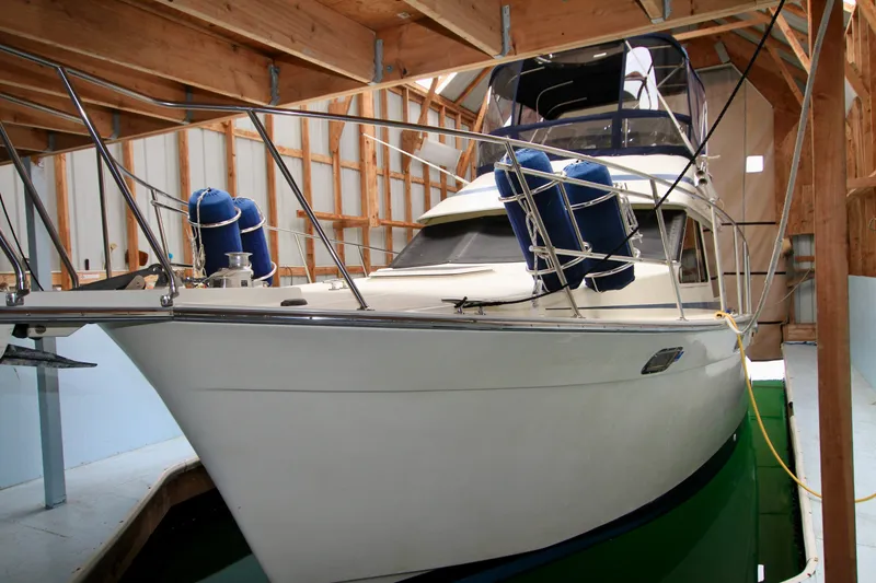 Slide: The Image of 1989 Tollycraft 34 Sport Sedan docked in a covered marina. - 1