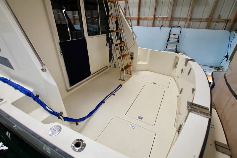 Slide: The Image of 1989 Tollycraft 34 Sport Sedan boat interior with spacious deck and ladder. - 11