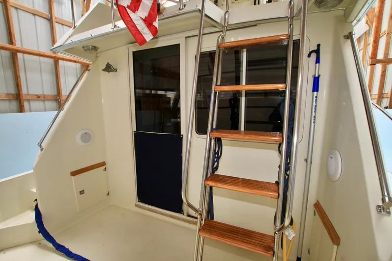 Slide: The Image of 1989 Tollycraft 34 Sport Sedan boat interior with ladder and American flag. - 13