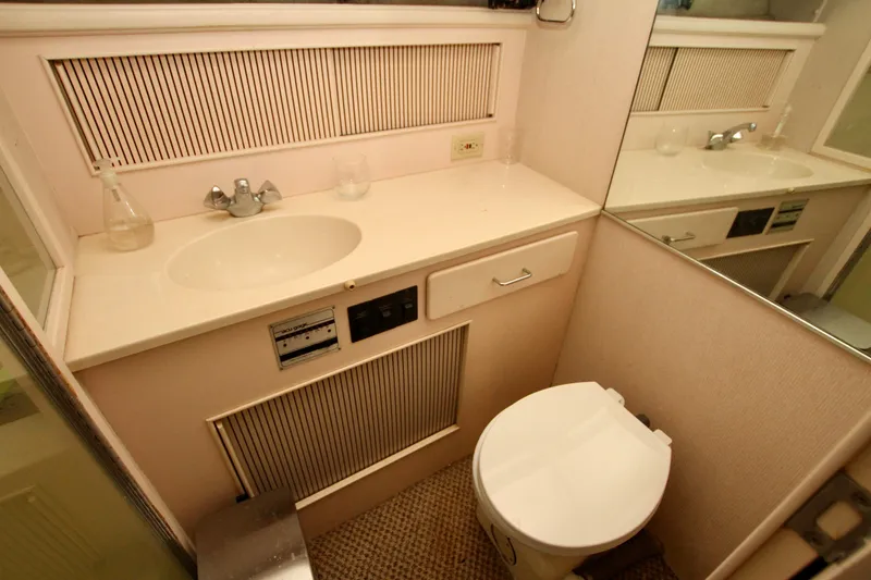 Slide: The Image of 1989 Tollycraft 34 Sport Sedan bathroom with sink, toilet, and mirrored wall. - 18