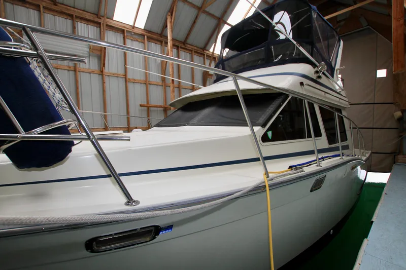 Slide: The Image of 1989 Tollycraft 34 Sport Sedan yacht in storage, showcasing sleek design and sturdy build. - 2