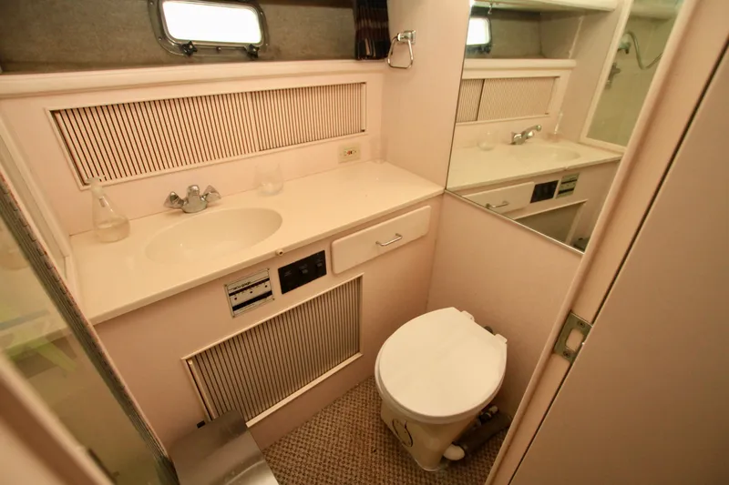 Slide: The Image of 1989 Tollycraft 34 Sport Sedan bathroom with sink, toilet, and mirror. - 21