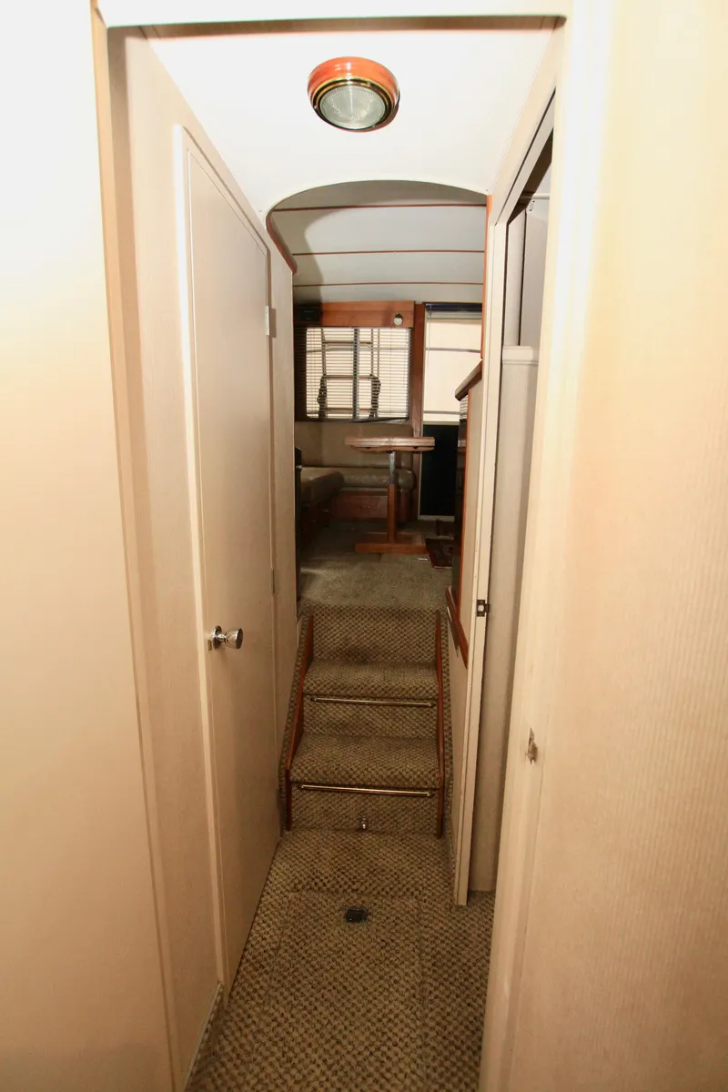 Slide: The Image of Interior hallway of 1989 Tollycraft 34 Sport Sedan with carpeted steps and wooden accents. - 24