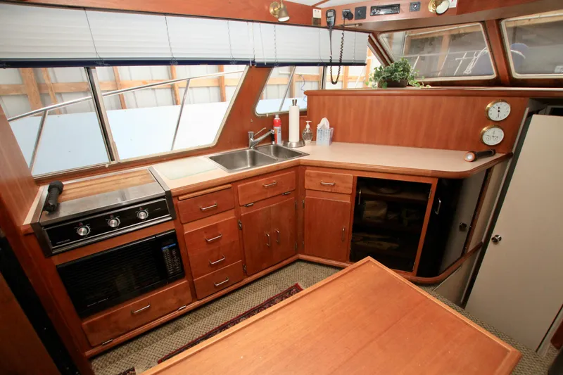 Slide: The Image of 1989 Tollycraft 34 Sport Sedan interior with kitchen, wooden cabinets, and appliances. - 29