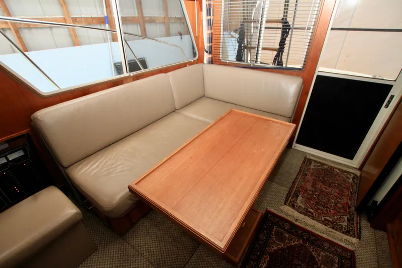 Slide: The Image of Interior of 1989 Tollycraft 34 Sport Sedan with beige seating and wooden table. - 32